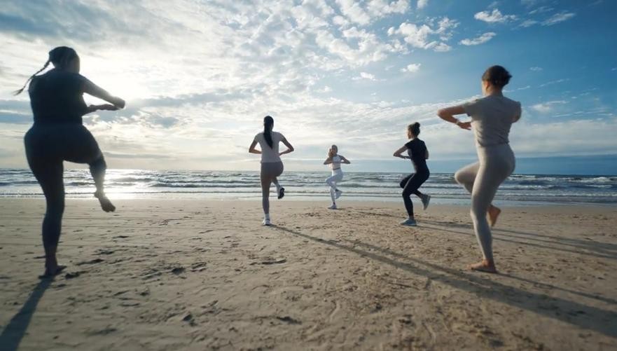 Smartwatch untuk Berlari - Panduan Terbaik Peningkat Performa Anda! 1 Seorang pelari wanita sedang menggunakan smartwatch untuk berlari di jalur lari outdoor